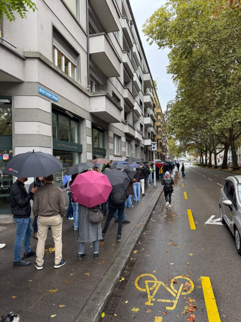 Wartende mit Regenschirmen vor dem serbischen Generalkonsulat an der Alfred-Escher-Strasse in Zürich